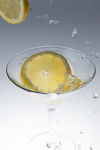 Lemon falls into a glass with water 1 by Marc Heiligenstein