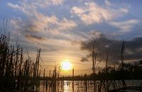 Das letzte Sonnenlicht leuchtet über das Wasser.