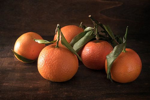 verse clementinevruchten met bladeren op een donkere rustieke houten achtergrond, geselecteerde focu