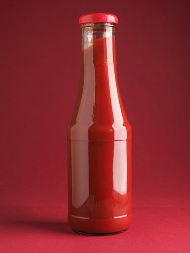 Fles lekkere biologische ketchup op rood