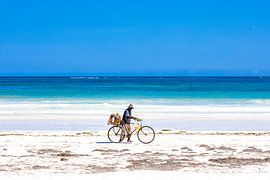 Tropischer weißer Strand mit azurblauem Meer und blauem Himmel und einem Radfahrer von Steven World Traveller