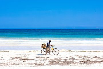Tropisch wit strand met azuurblauwe zee en blauwe lucht en een fietser van Steven World Traveller