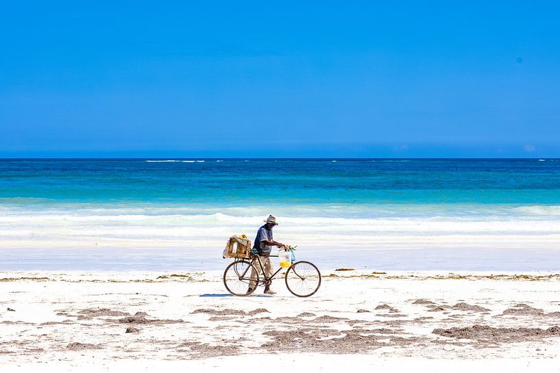 Plage blanche tropicale avec mer azur et ciel bleu et un cycliste par Steven World Traveller