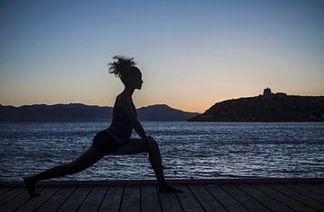 SA11335628 Junge Frau, die nachts am Meer Yoga praktiziert von BeeldigBeeld Food & Lifestyle