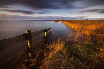 The last warm light of a cold winter day illuminates the landscape near the National Park Lauwersmee by Bas Meelker