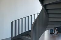 Escalier en colimaçon montrant deux paires de pieds, une paire d'un personnage masculin et une paire de pieds d'une jeune fille timide.