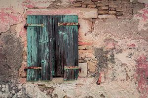 Alter blau-türkiser Fensterrahmen mit rostigen Scharnieren