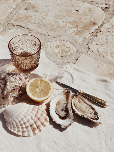 Huîtres, citron et verres sur la pierre – Nature morte en bord de mer