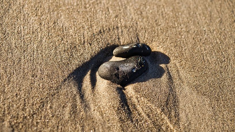 Heart-shaped stone in the sand of the Baltic Sea beach by Martin Köbsch