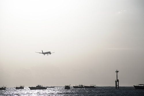 Landend vliegtuig boven zee tijdens zonsondergang High Key sur Chantal Schutte