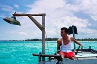 Jonge kapitein kijkt over blauwe, tropische Indonesische zee