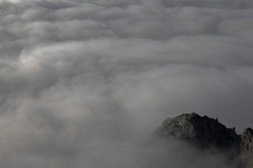 Spits van berg omringt door wolken.