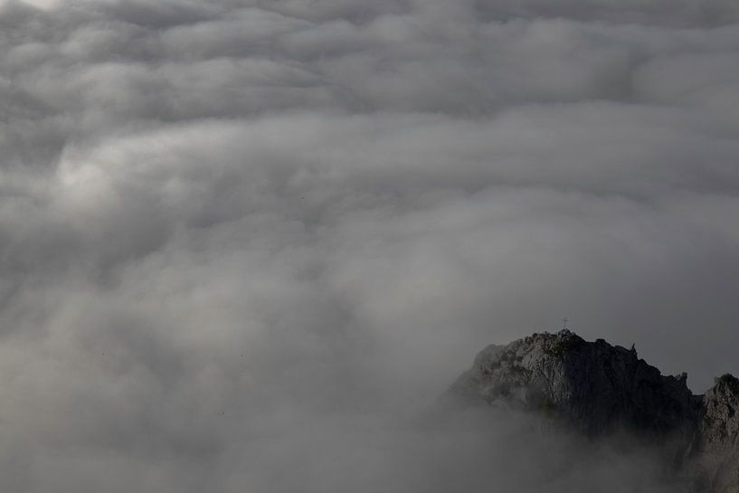 Peak of mountain surrounded by clouds. by Raf Eussen