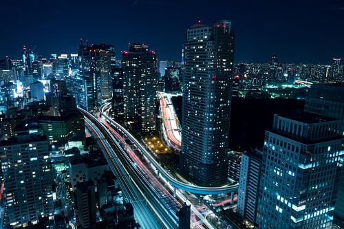 City in motion with traffic and tower buildings in the dark