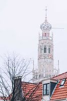 Winterse Bakenesserkerk achter grachtenpand in Haarlem