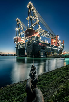 's Werelds grootste half afzinkbare kraanschip Sleipnir in de haven van Rotterdam in de avond.