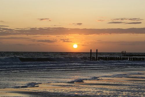 golfbrekers op het strand van westkapelle met zonsondergang
