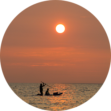 Vader en zoon, bij zonsondergang, peddelend op zee (staand) van Simone Kuijpers