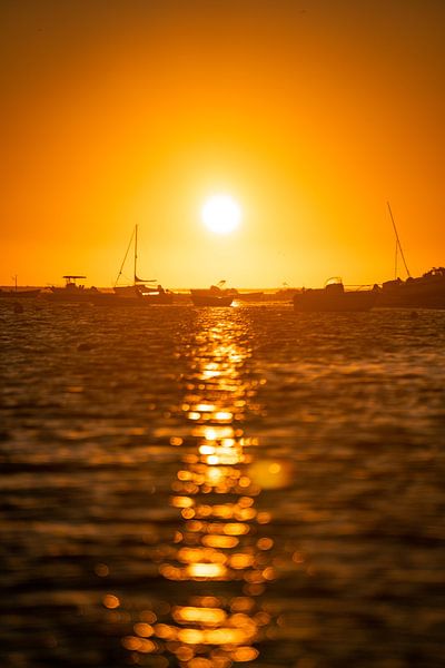 Lever de soleil sur la côte de l'Algarve avec des bateaux et la mer scintillante par Leo Schindzielorz