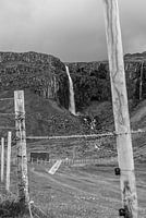 Grenze der Natur: Wasserfall und Zaun in der Stille