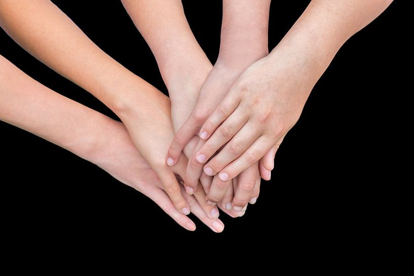 Multiple arms of children with hands together isolated on black background by Ben Schonewille