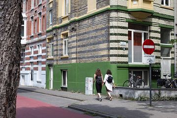 Ein Paar geht eine bunte Straße in Gent, Belgien, entlang von Jochem Oomen