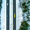 Autobahn durch eine verschneite Waldlandschaft von oben gesehen von Sjoerd van der Wal