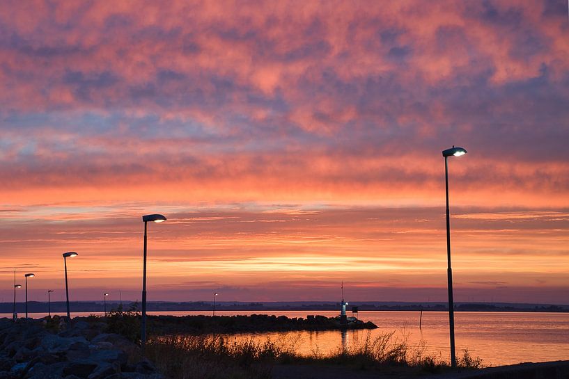 Lighthouse in the harbour at sunset by Martin Köbsch