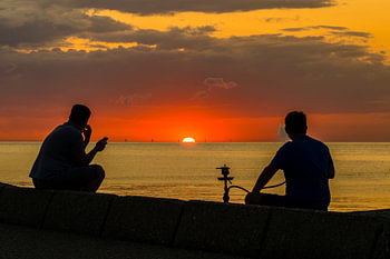 genieten van de waterpijp tijdens zonsondergang