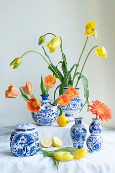 Uitbundig stilleven met tulp,citroen, gerbera in  delfts blauwe vaasjes lichte achtergrond