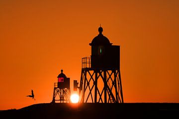 Coucher de soleil au port de Stavoren entre les deux phares. sur Harrie Muis