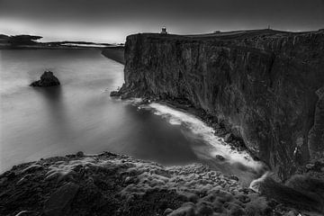 Leuchtturm auf Island mit Steilküste am Meer in schwarzweiss. von Manfred Voss, Schwarz-weiss Fotografie