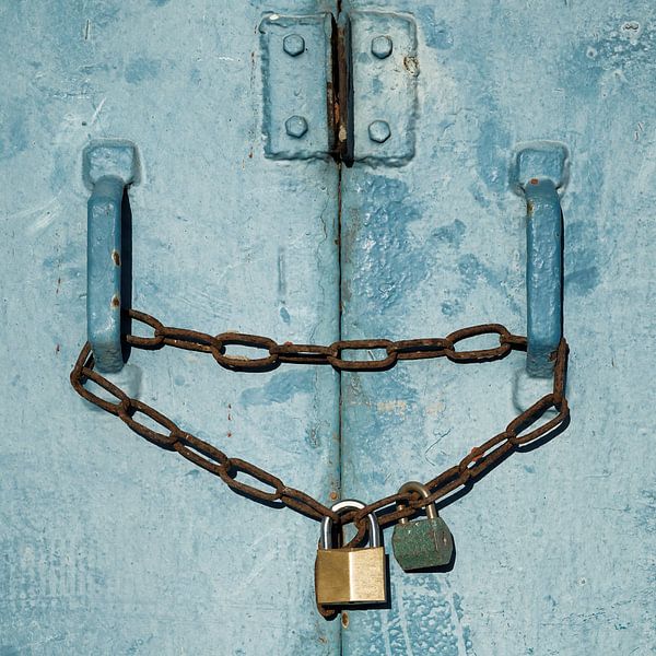 Padlocks in front of a blue steel door by Heiko Kueverling