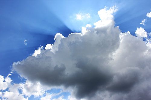 Zon straalt scherp langs de wolken.