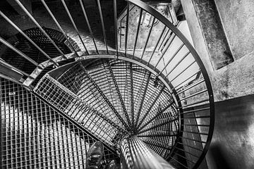 Schwarze Spindeltreppe aus Stahl mit Gitterroststufen, die sich um den Drehpunkt windet von Jan Willem de Groot Photography