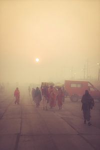 Mensen die in de mist lopen tijdens de Kumbh Mela in India