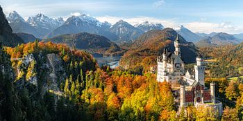 Panorama of Neuschwanstein castle, Marienbrücke bridge and Alpsee lake. Snow covered mountains in th