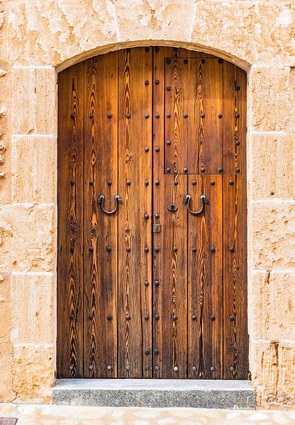 Brown wooden front door with sandstone arch, front view by Alex Winter