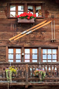 Skies aan de muur en geraniums op het balkon in Zwitserland