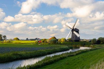 Typisch Hollands: Molen in het weiland met draaiende wieken van Bram Lubbers