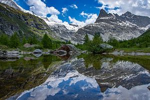 Weerspiegeling Alpen in een bergmeertje van Marc van Dijken
