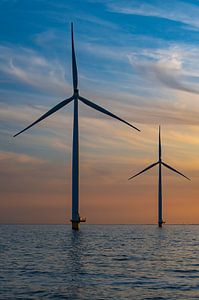 Windturbinen in einem Offshore-Windpark bei Sonnenuntergang