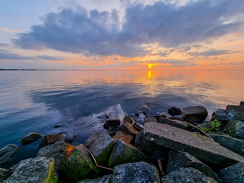 Coucher de soleil aux couleurs pastel sur des eaux calmes