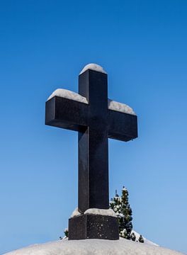 Besneeuwd kruisbeeld op een begraafplaats