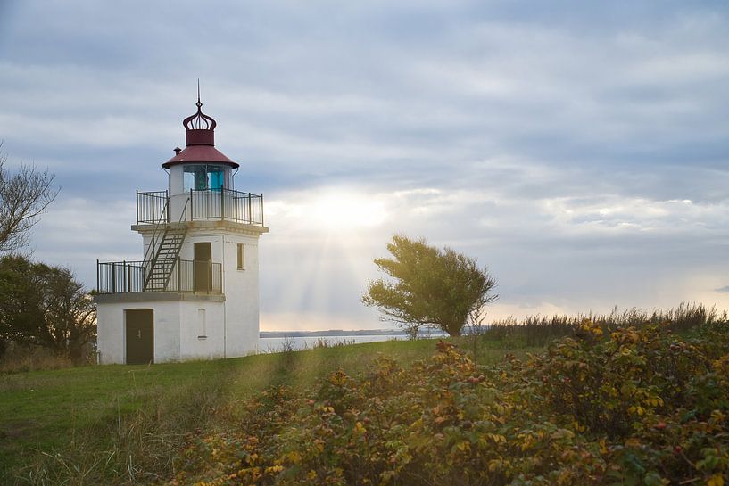 Lighthouse by the sea and rays of sunshine by Martin Köbsch