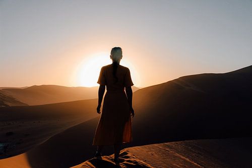 Vrouw bij zonsopkomst in Sossusvlei Nationaal Park, Namibie