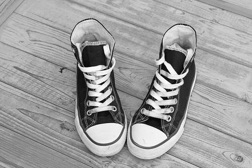 Canvas sneaker shoes on vintage wooden background