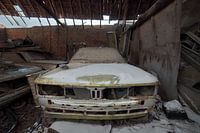 Urbex green car with snow on the hood.