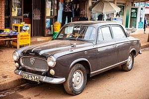 Une vieille voiture sur une route de terre à Kampala, en Ouganda