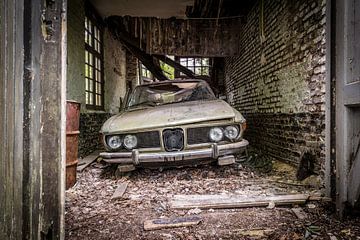 Oude auto in vervallen garage van Inge van den Brande